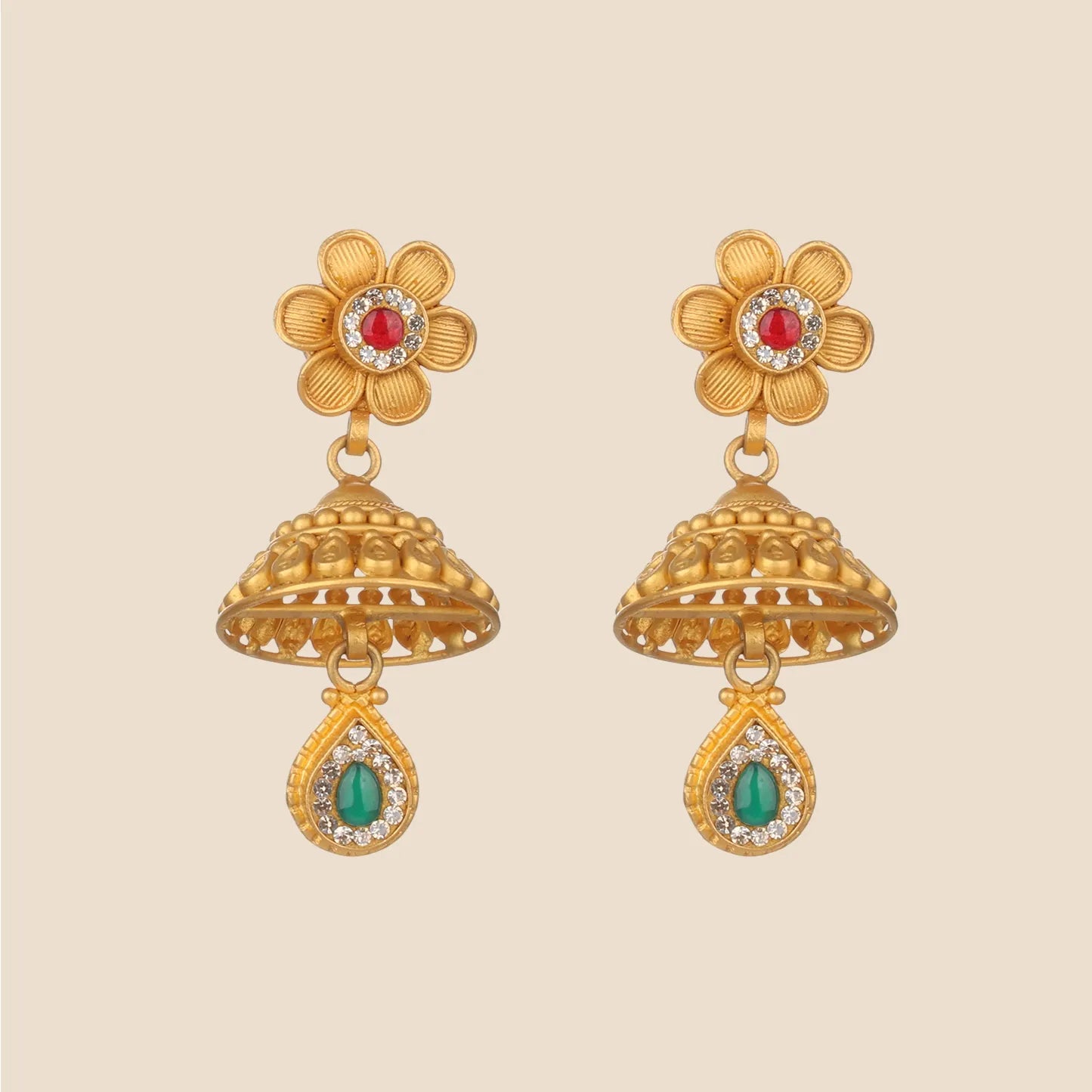 Gold jhumka earrings featuring a floral stud with a red center stone, a textured bell, and a teardrop dangle with a green stone.