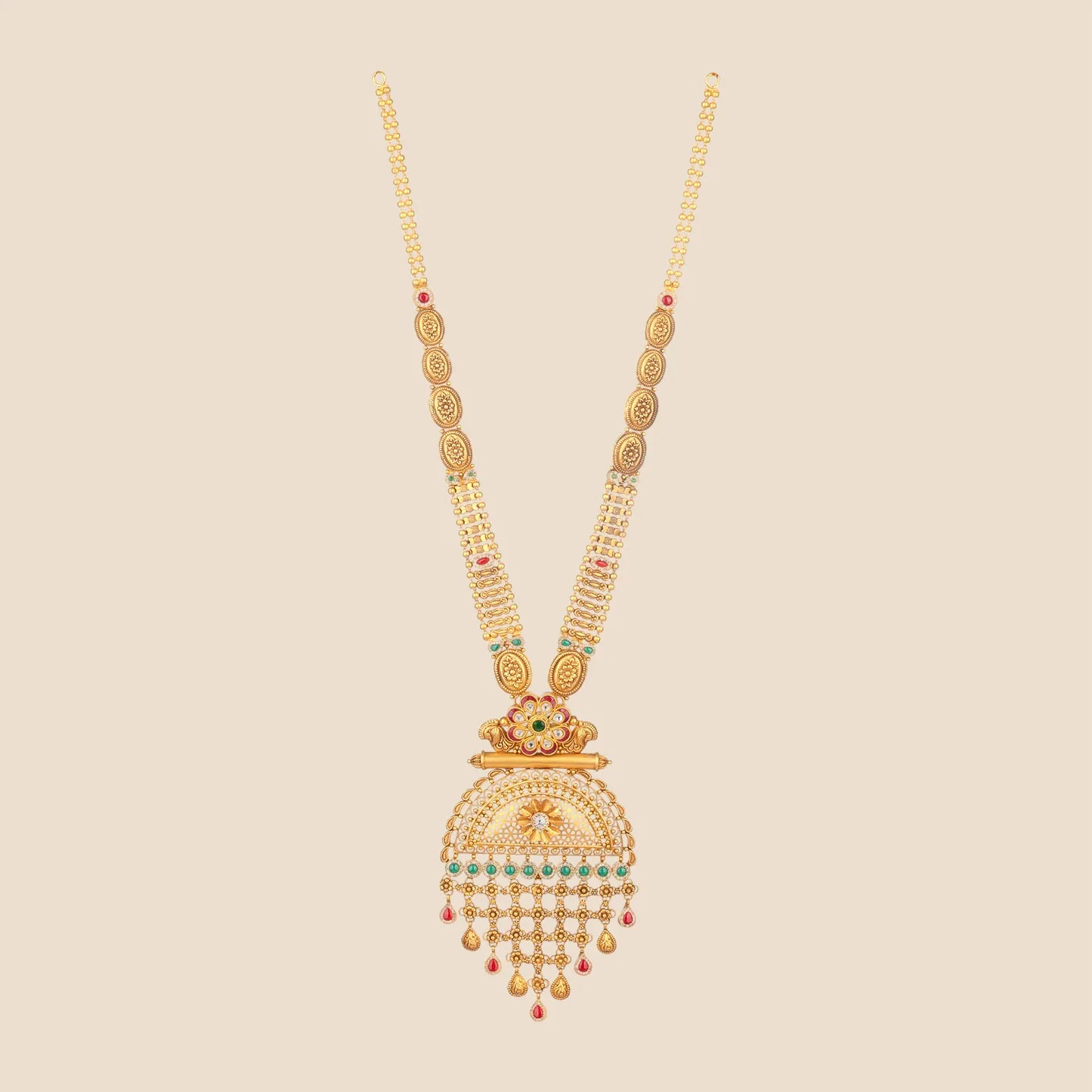Long traditional gold necklace with a beaded chain leading to a large, intricate pendant featuring floral motifs, green stones, and a multi-tiered fringe of gold and red stone drops.