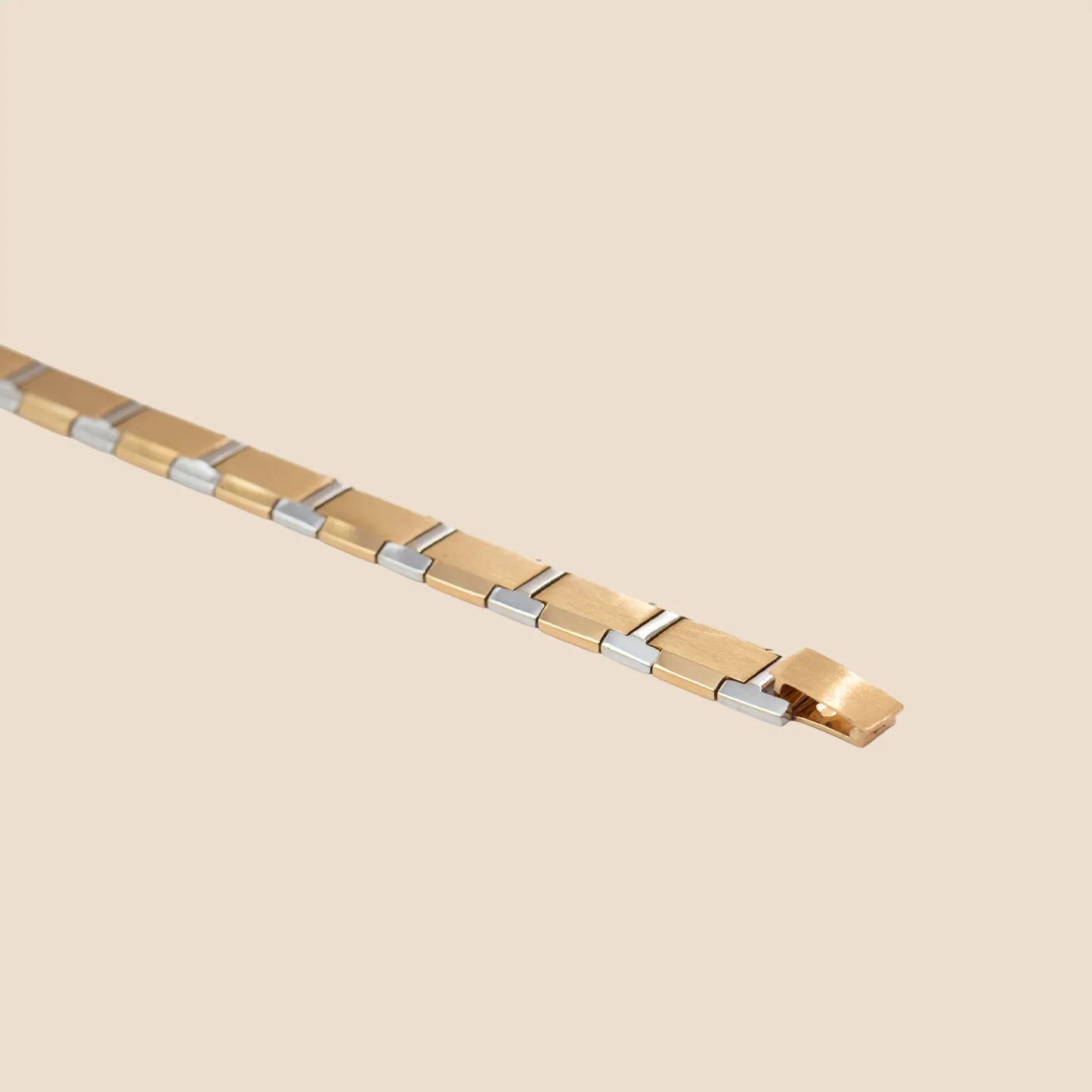 Gold and silver bracelet on a beige background