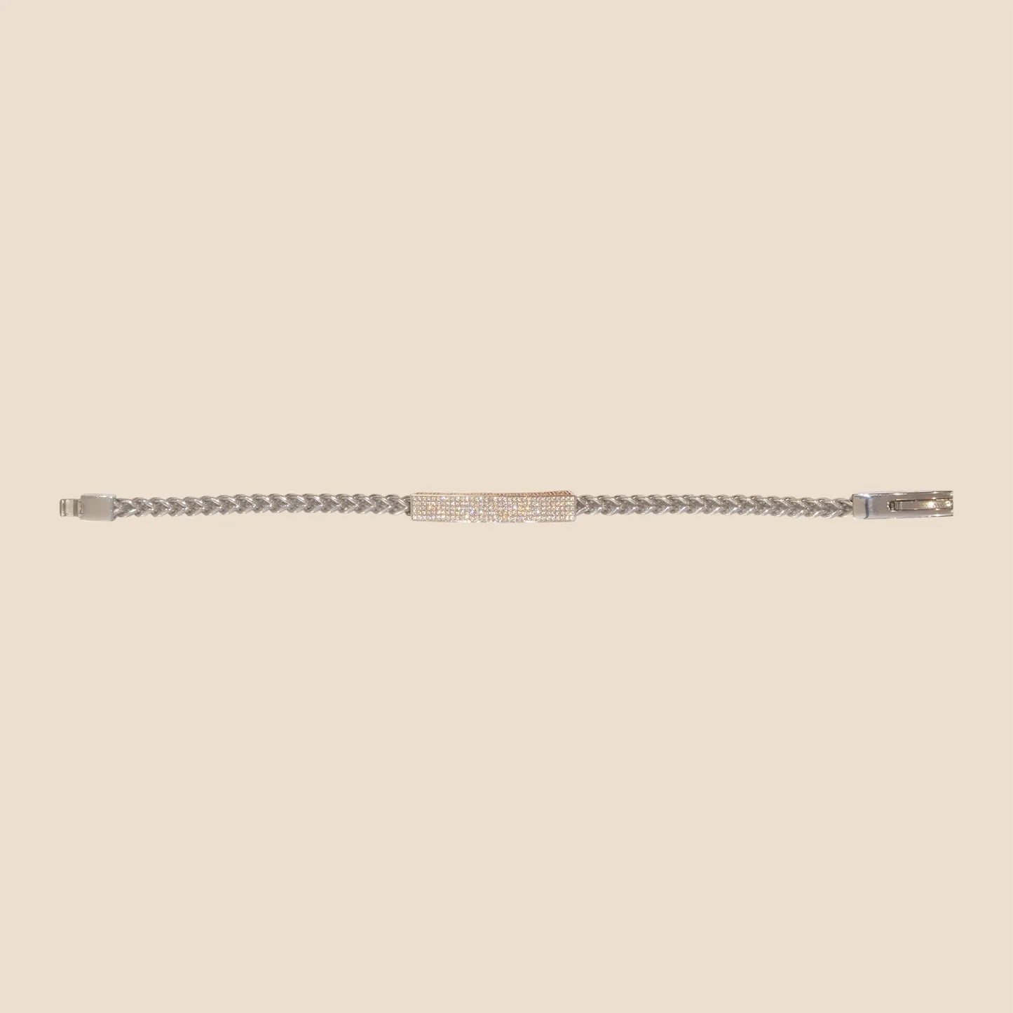 Silver bracelet with a small red gemstone on a beige background