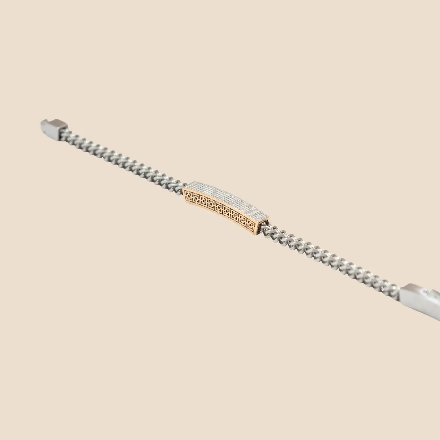 Silver bracelet with gold accents on a beige background