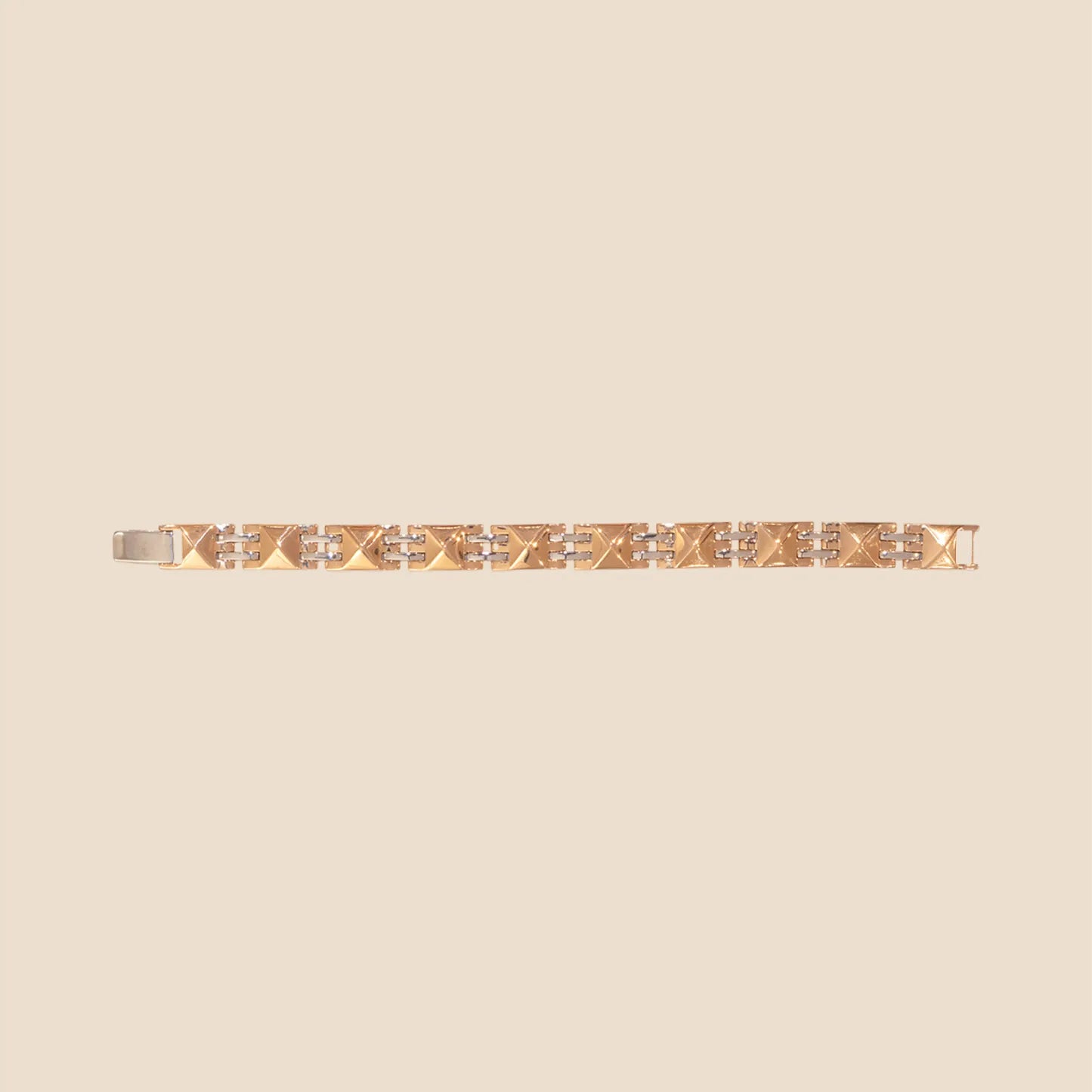 Gold bracelet with diamond accents on a beige background