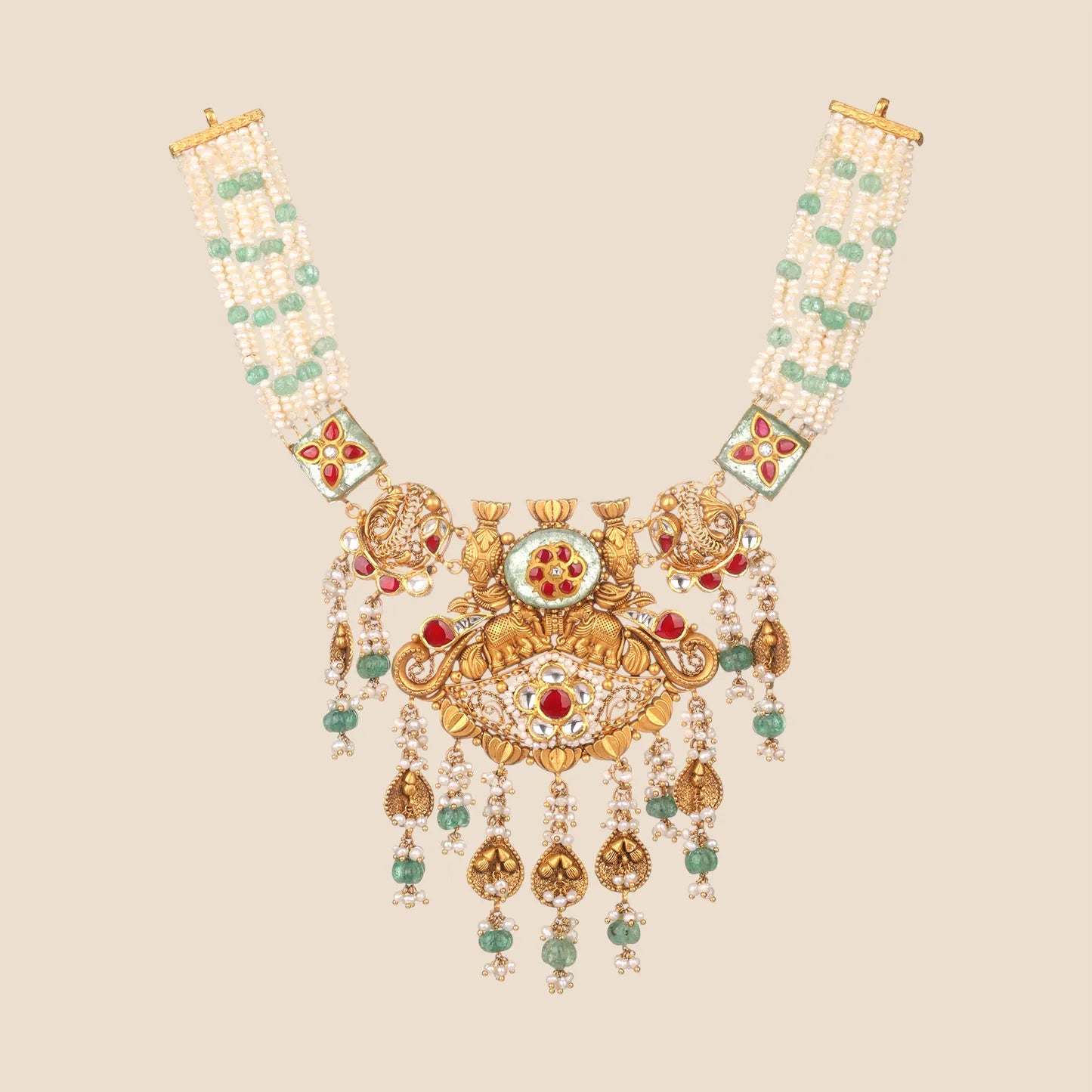 A stunning gold long necklace featuring a central floral motif with red gemstones and green accents, multi-strand gold chains, and tiered golden dangles.