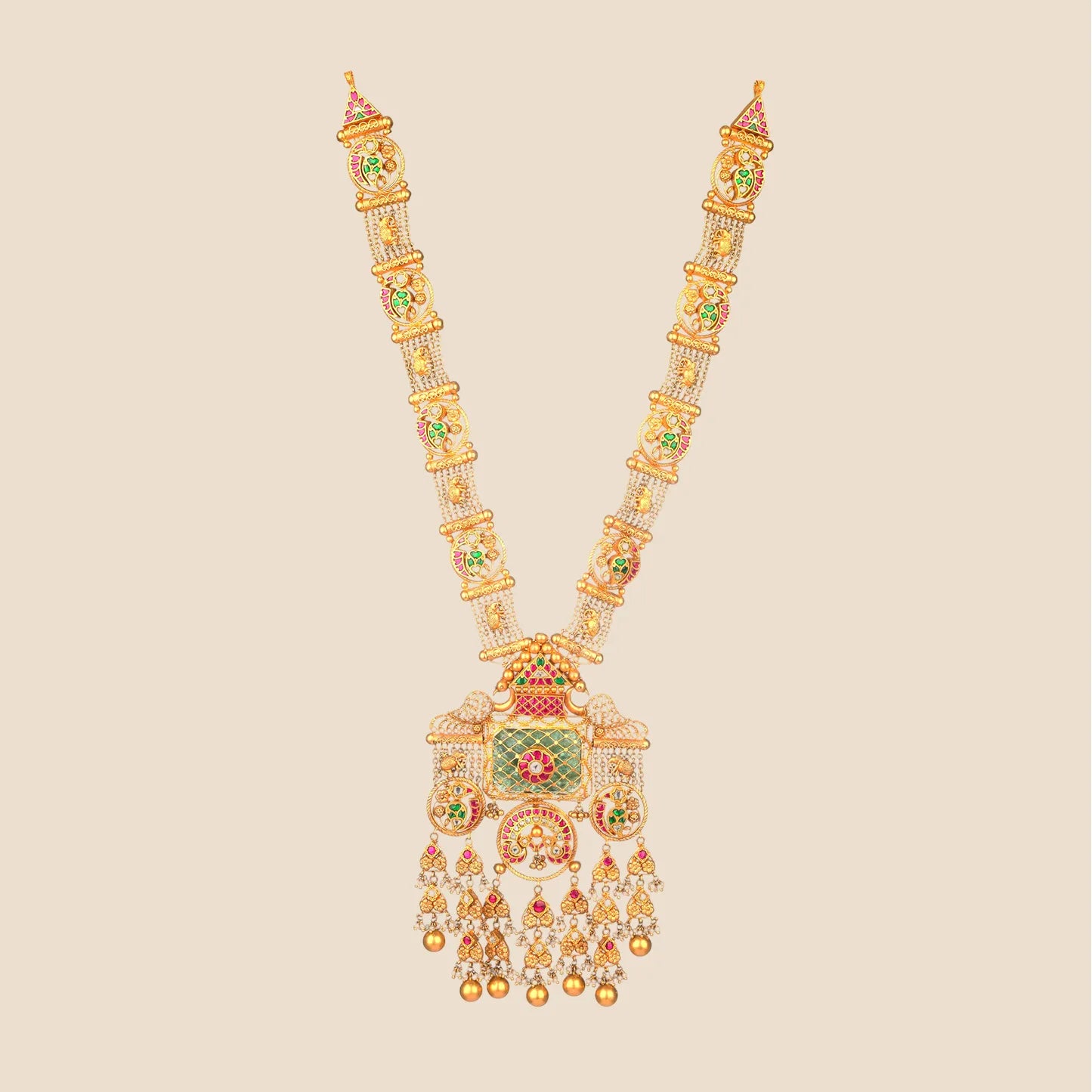 Long traditional gold necklace with a multi-strand beaded chain leading to a large, intricate pendant detailed with a rectangular green stone, elephant motifs, and cascading gold drops.
