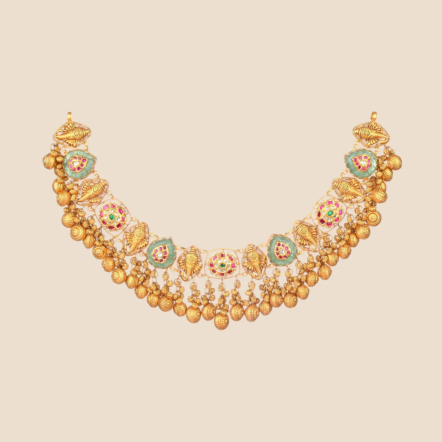 Ornate gold choker necklace detailed with green teardrop stones, gold elephant motifs, and a dense fringe of hanging gold beads.