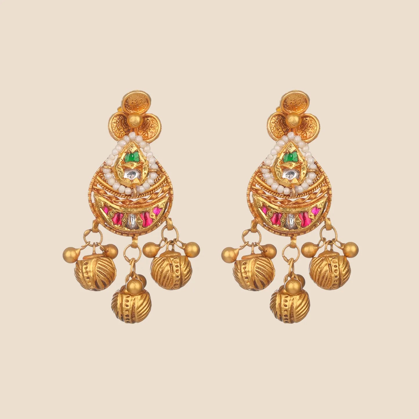 Gold earrings with emerald centers, winged accents, and dangling temple-style charms.