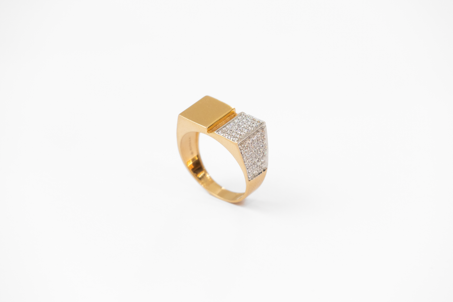 Gold ring with diamond-studded band on a white background