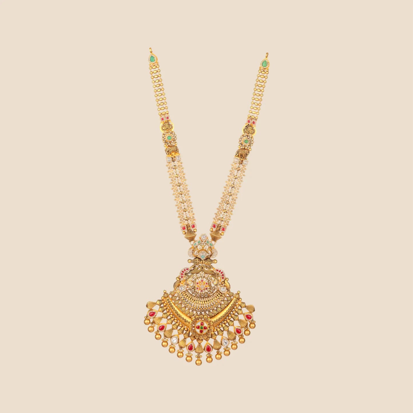 Long traditional gold necklace featuring a multi-strand beaded chain with tiny elephant motifs and a large, elaborate pendant adorned with green and red stones and cascading gold drops.
