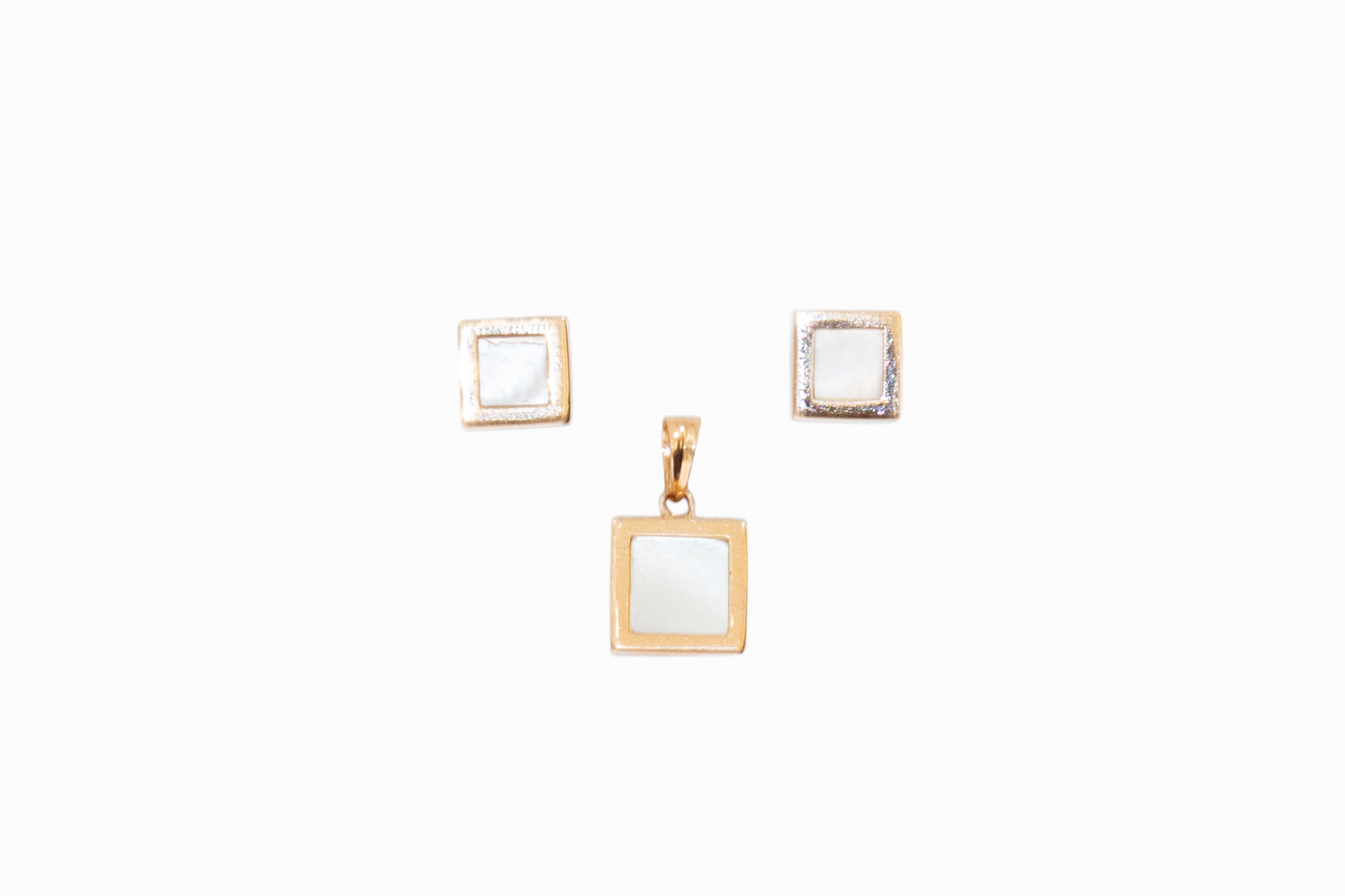 Gold square pendant and earrings on a white background