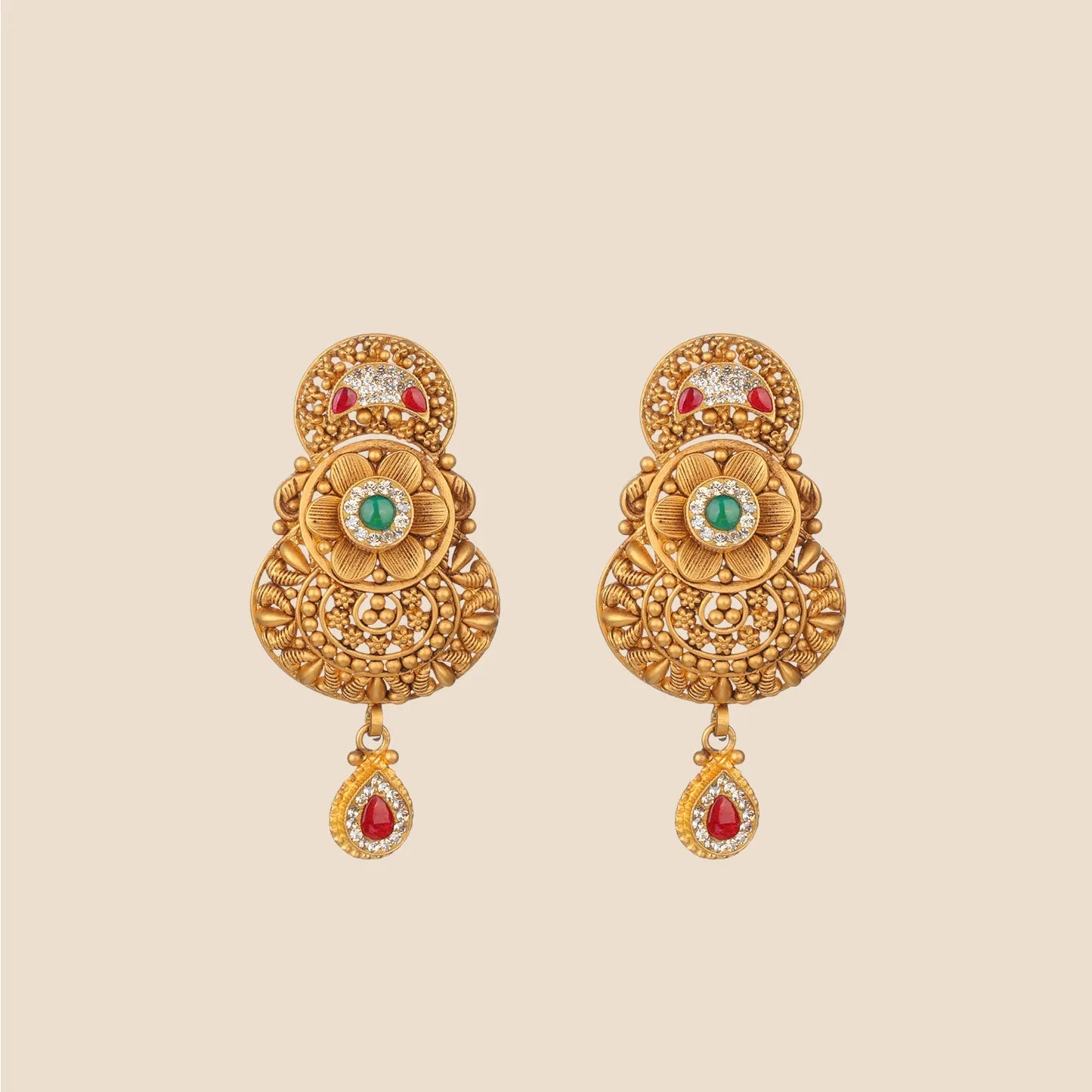 Ornate gold dangle earrings featuring a floral center with a green stone, red stone accents on the top and bottom, and intricate filigree work.
