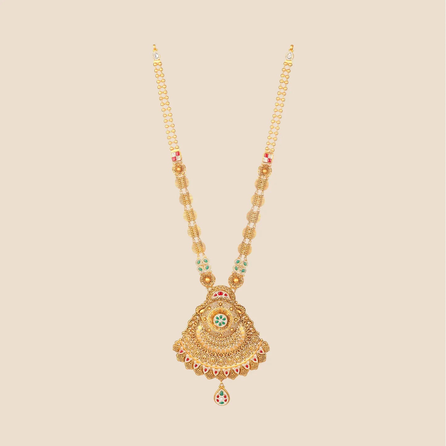 Long traditional gold necklace featuring a beaded chain with circular motifs and a large, bell-shaped pendant detailed with green and red stones and a teardrop dangle.