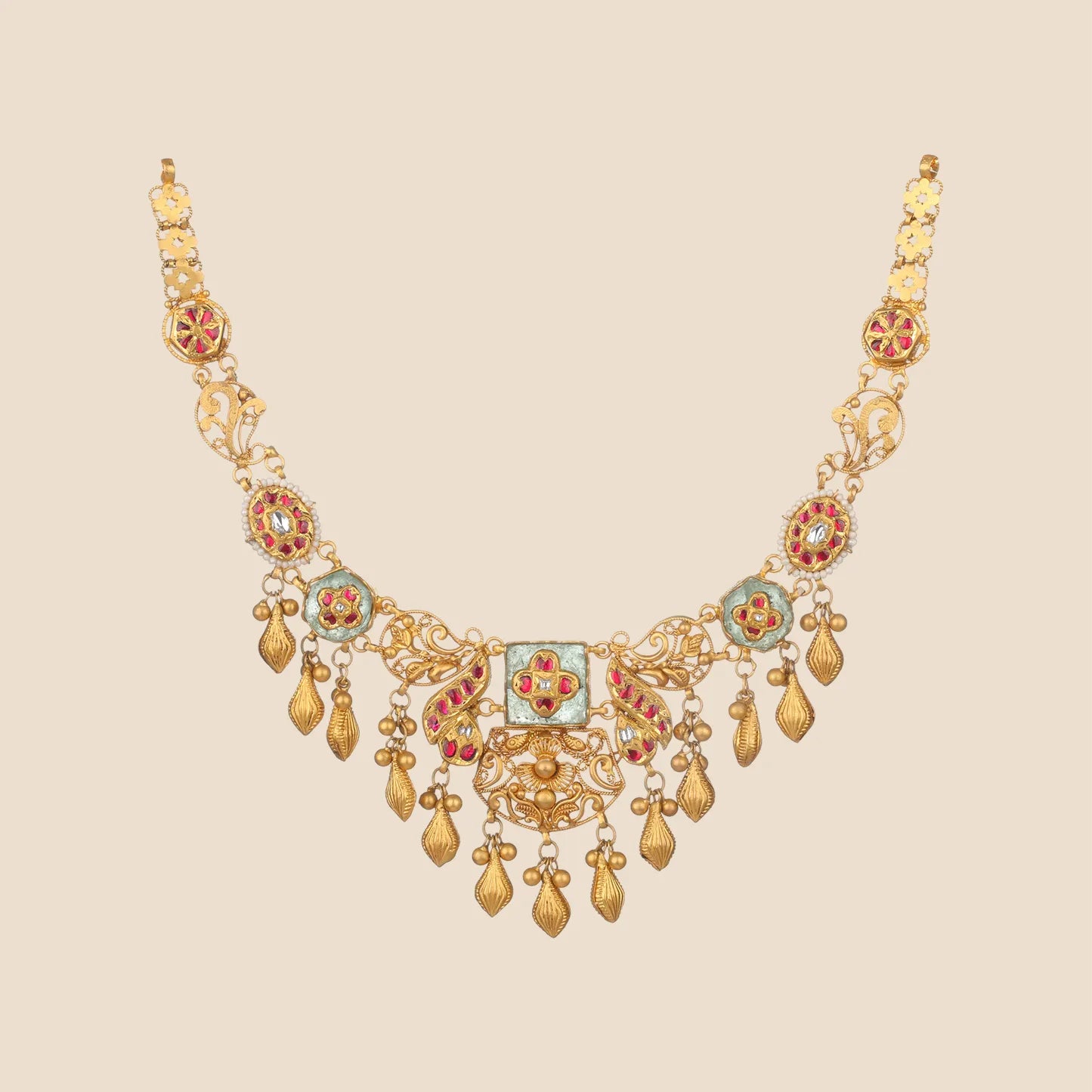 An intricate gold choker necklace featuring red gemstone accents, floral filigree patterns, and dangling gold leaf droplets.