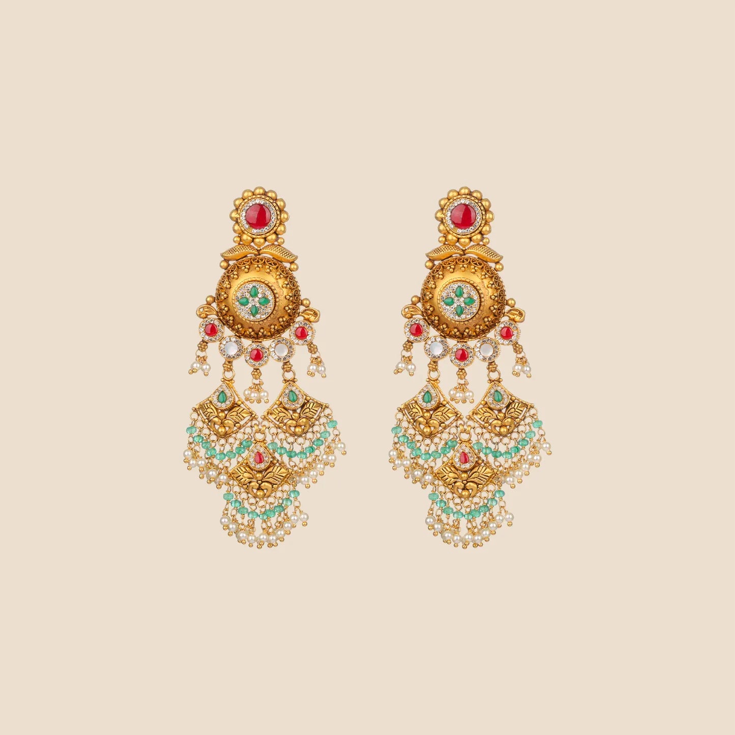 Antique gold chandbali earrings with ruby and emerald stones, pearl and turquoise bead tassels, and intricate floral filigree detailing.