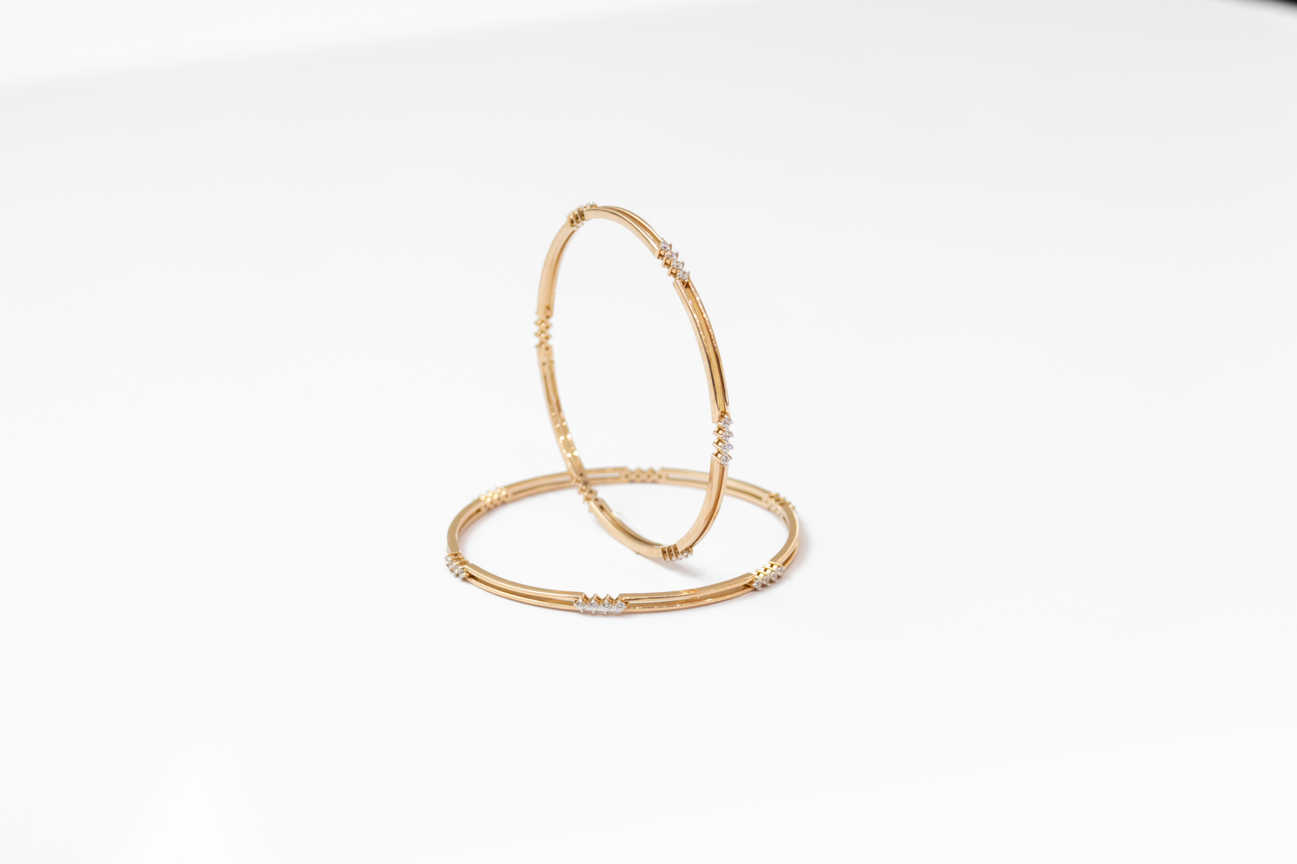 Two gold bangles on a white background