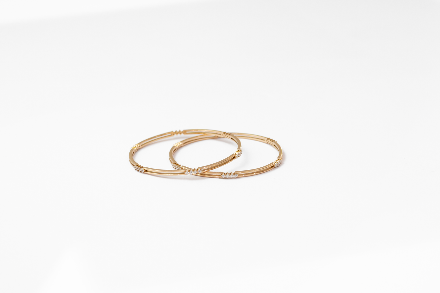 Women Two gold bangles on a white background