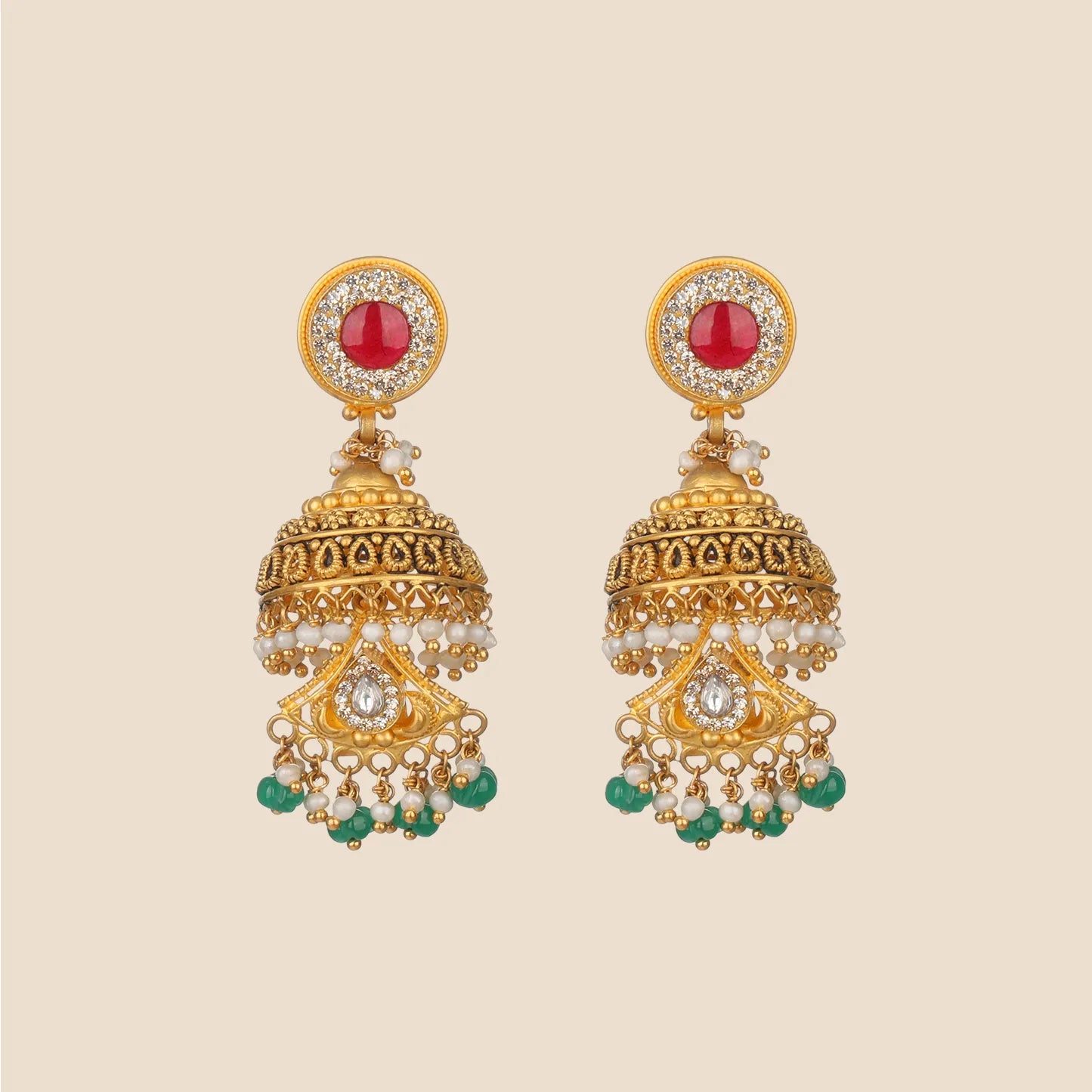 Ornate gold jhumka earrings featuring a round red stone top surrounded by clear stones, a detailed bell, and a cascading fringe of green beads and pearls.