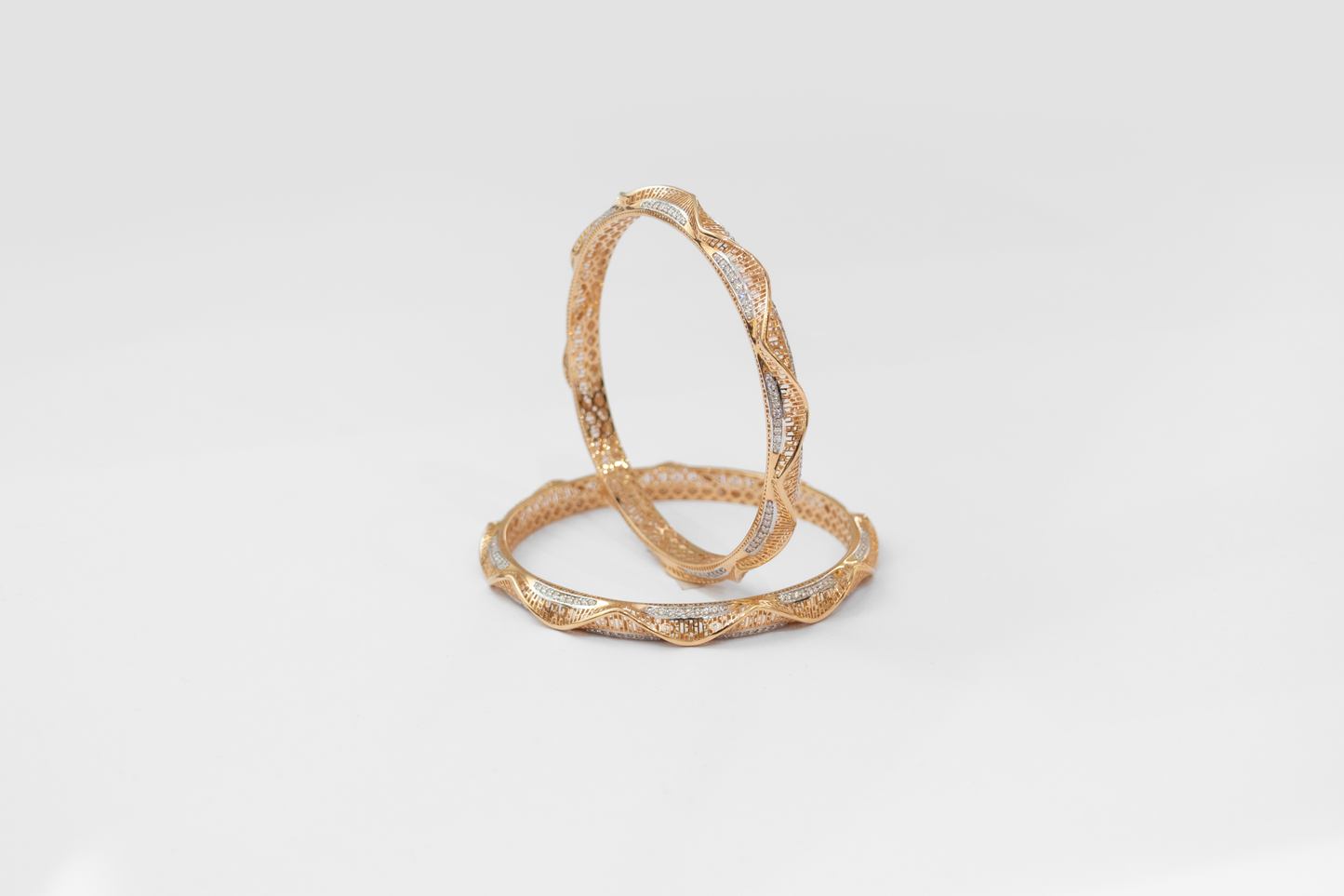 Gold bangles on a light gray background