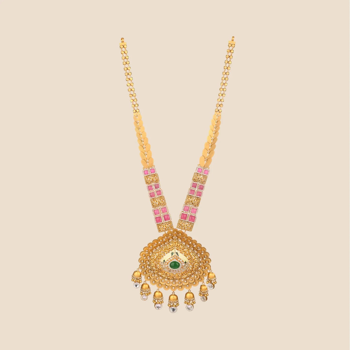 Long gold necklace featuring pink square stone links and a large circular sunburst pendant with a green stone center and cascading gold drops.
