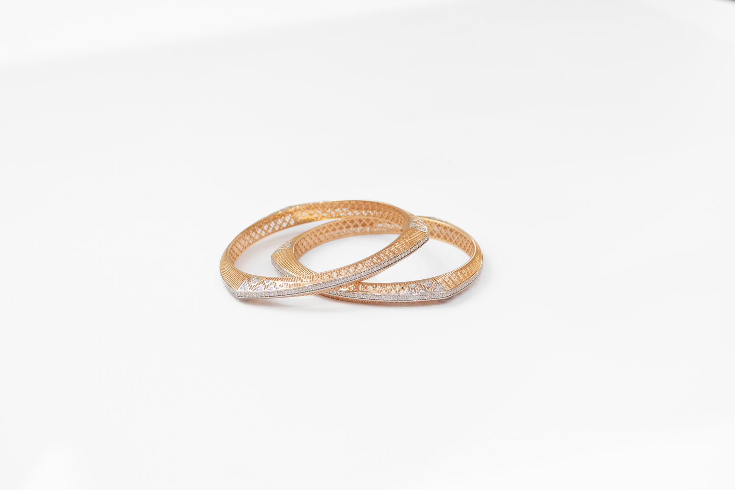 Two gold bangles on a white background