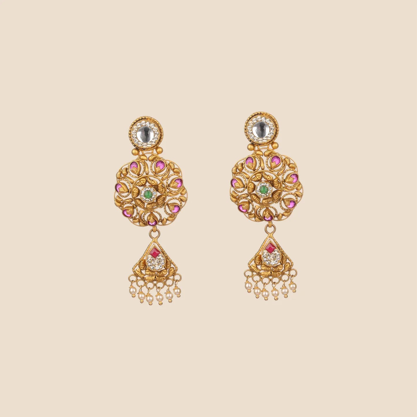 Ornate gold dangle earrings featuring a circular filigree design accented with pink and green stones, a clear stone stud, and a triangular drop finished with small hanging pearls.