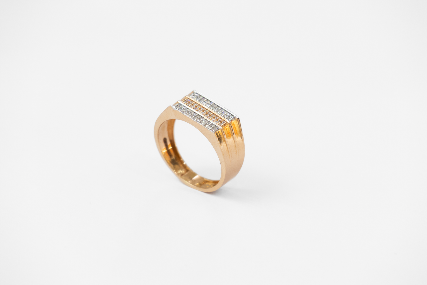 Gold ring with diamond accents on a white background