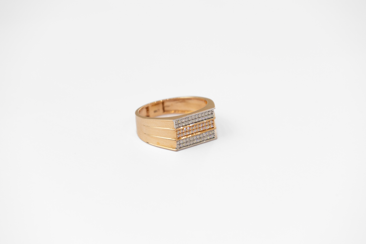 Gold ring with embedded stones on a white background