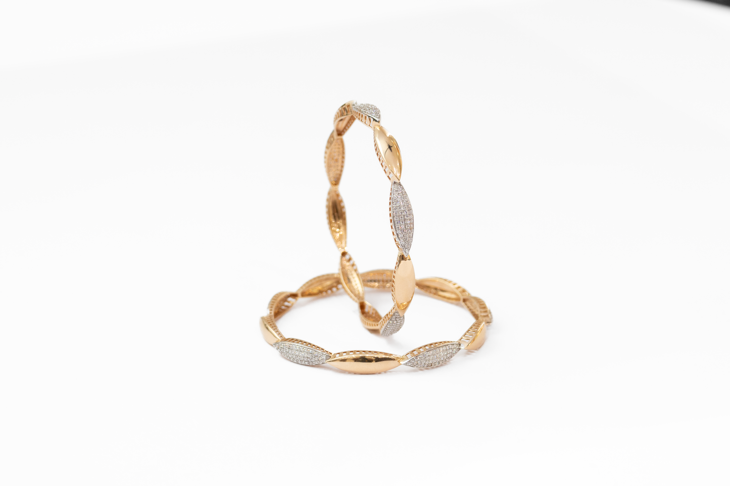 Gold bangles with silver accents on a white background