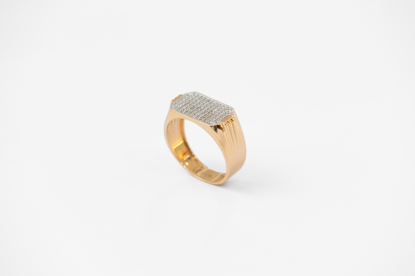 Gold ring with diamond-studded band on a white background